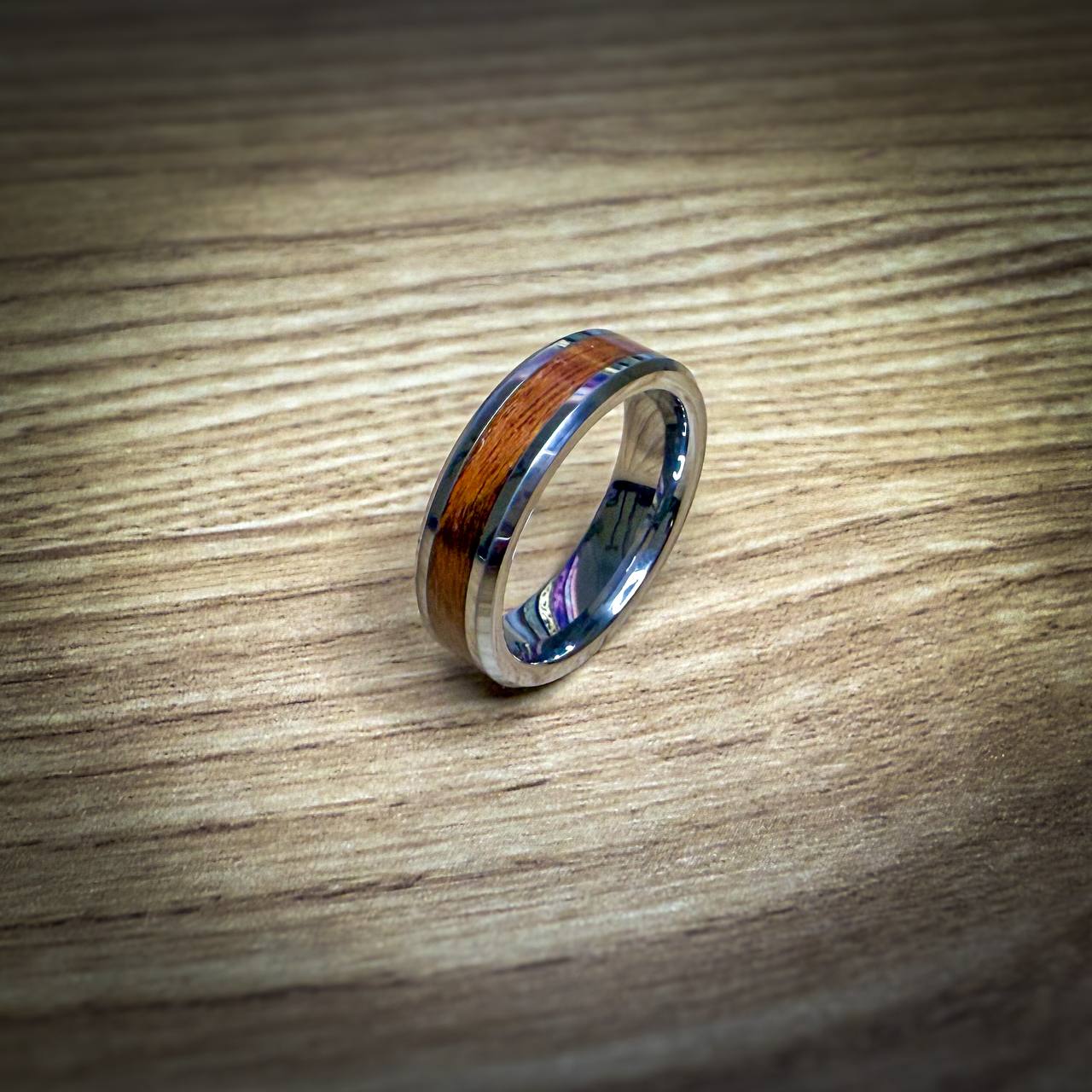 Silver ring with a Santos Rosewood inlay on a wooden surface