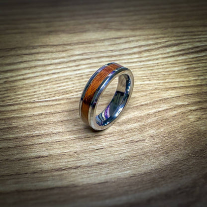 Silver ring with a Santos Rosewood inlay on a wooden surface